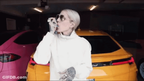 A Woman Wearing Sunglasses Is Standing In Front Of A Ford Car GIF