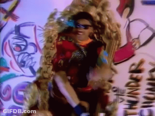 A Woman Wearing Sunglasses Is Standing In Front Of A Wall That Says Thunder GIF