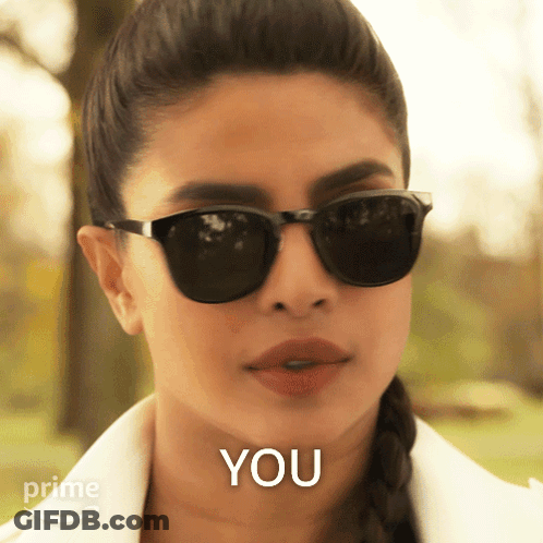 A Woman Wearing Sunglasses Says " You " In Front Of Her GIF