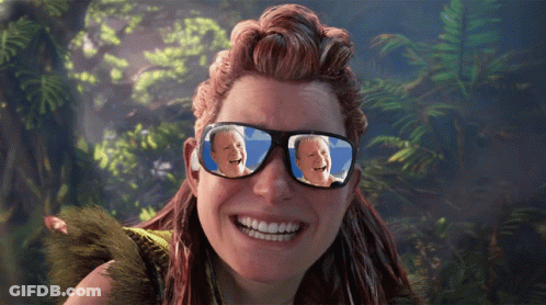 A Woman Wearing Sunglasses With A Picture Of A Man Laughing In The Reflection GIF