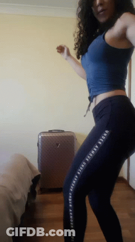 A Woman Wearing Under Armour Pants Is Dancing In A Room GIF