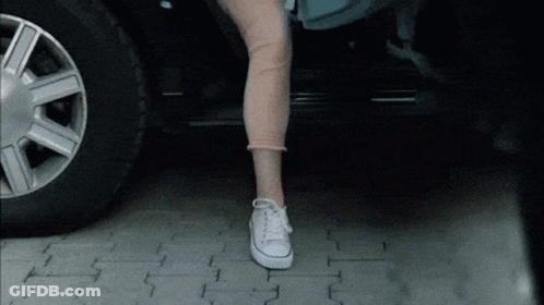 Woman In White Converse Standing On Brick Sidewalk GIF
