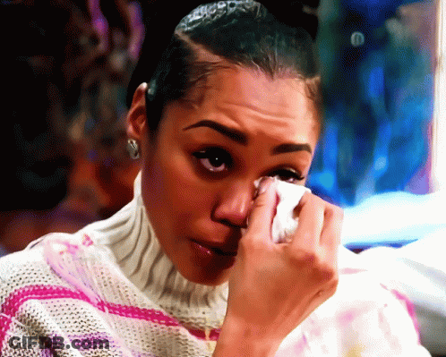A Woman Wipes Her Eyes With A Tissue In A Painting GIF