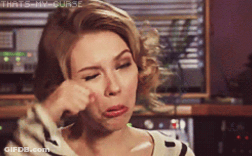 A Woman Wipes Her Face With Her Hand With The Words That 'S My Curse Written Above Her GIF