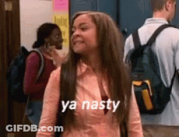 A Woman With A Backpack Is Standing In A Hallway And Says Ya Nasty . GIF