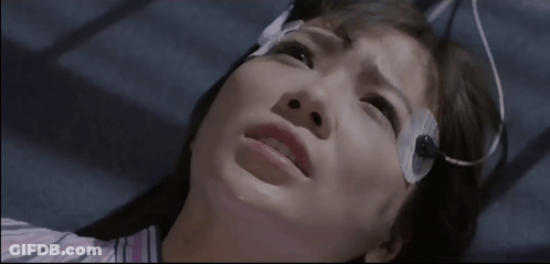 A Woman With A Bandage On Her Head Looks Up At The Camera GIF