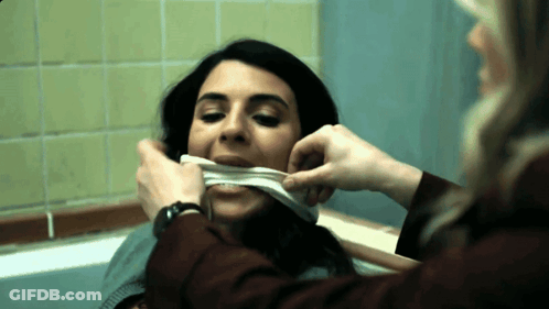 A Woman With A Bandage On Her Mouth Looks At Another Woman GIF