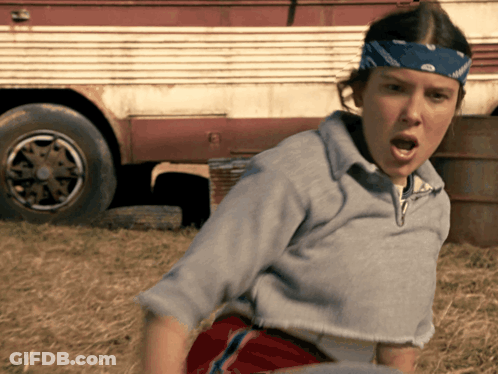 A Woman With A Bandana On Her Head Is Standing In Front Of A Truck GIF