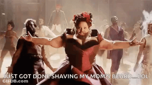 A Woman With A Beard Is Dancing With A Group Of People . GIF