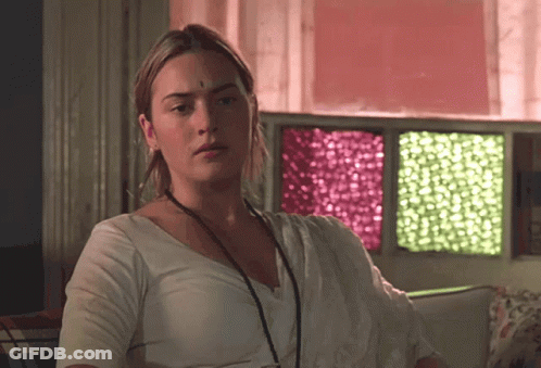 A Woman With A Bindi On Her Forehead Is Sitting In Front Of A Window GIF