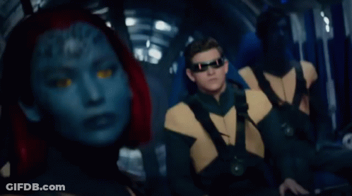 A Woman With A Blue Face And Red Hair Looks At The Camera GIF