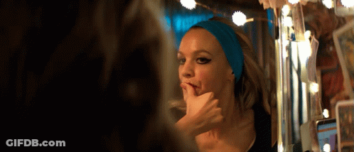 A Woman With A Blue Headband On Her Head Looks At Herself In A Mirror GIF