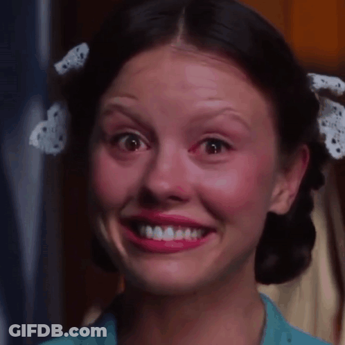 A Woman With A Bow In Her Hair Is Smiling And Making A Funny Face GIF