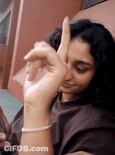 A Woman With A Bracelet On Her Wrist Is Giving A Thumbs Up Sign GIF