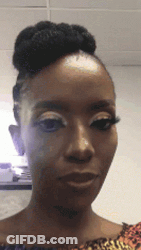A Woman With A Bun On Her Head Is Making A Funny Face . GIF