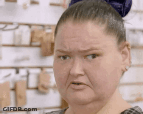 A Woman With A Bun On Her Head Is Making An Angry Face . GIF