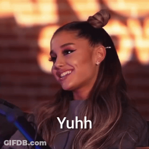A Woman With A Bun On Her Head Is Smiling With The Word Yuhh Above Her GIF