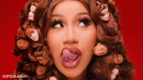 A Woman With A Bunch Of Barbie Doll Heads In Her Hair GIF