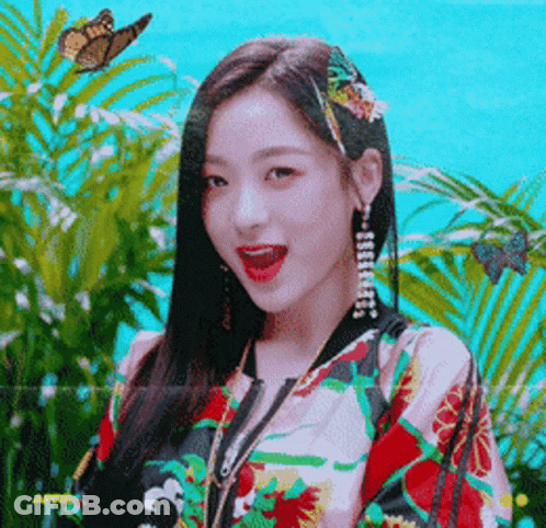 A Woman With A Butterfly In Her Hair Is Wearing A Jacket With Flowers On It GIF