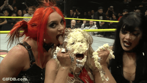 A Woman With A Cake On Her Face Is Surrounded By Two Women GIF