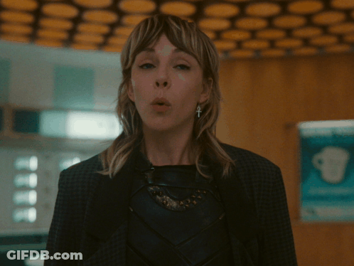 A Woman With A Cross On Her Ear Looks Surprised GIF
