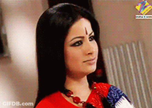 A Woman With A Cross On Her Forehead Wears A Red Shirt GIF