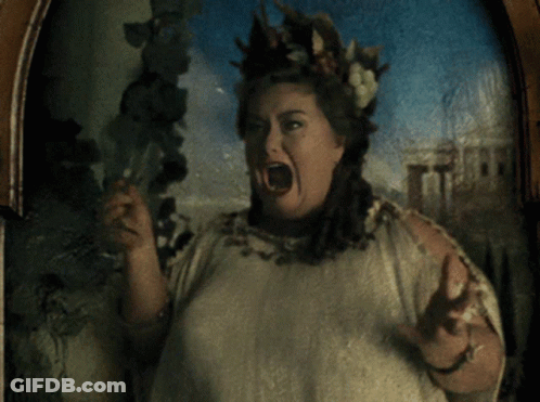 A Woman With A Crown Of Leaves On Her Head Holds A Glass GIF