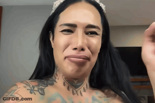 A Woman With A Crown On Her Head And A Tattoo On Her Chest GIF