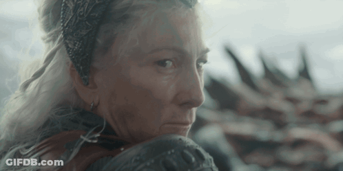 A Woman With A Crown On Her Head Is Looking Over Her Shoulder GIF