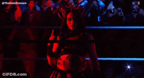 A Woman With A Crown On Her Head Is Standing In A Wrestling Ring GIF