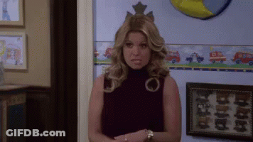 A Woman With A Crown On Her Head Is Standing In Front Of A Wall With A Picture Of A Fire Truck On It GIF