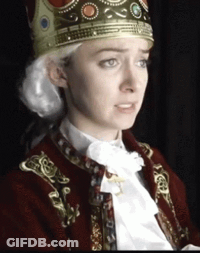 A Woman With A Crown On Her Head Is Wearing A Red Jacket GIF
