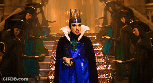 A Woman With A Crown On Her Head Stands In Front Of A Group Of People GIF