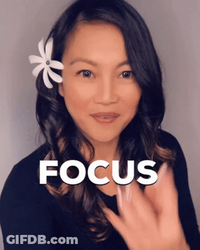 A Woman With A Flower In Her Hair Has The Word Focus Above Her Head GIF