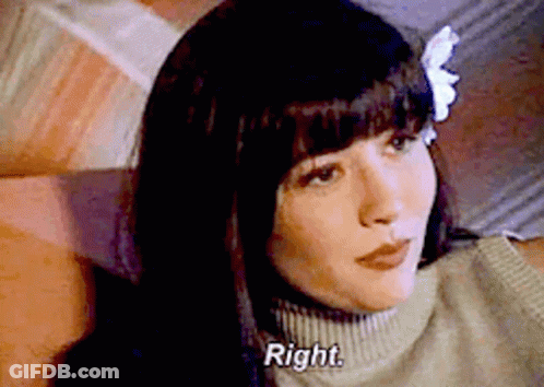 A Woman With A Flower In Her Hair Is Sitting On A Couch . GIF