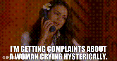 A Woman With A Flower In Her Hair Is Talking On A Phone . GIF