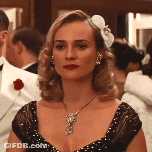 A Woman With A Flower In Her Hair Wears A Necklace GIF