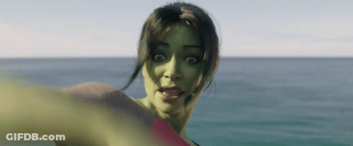 A Woman With A Green Face Is Standing In The Ocean GIF