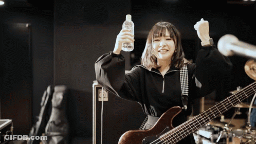 A Woman With A Guitar Is Holding A Bottle Of Water GIF