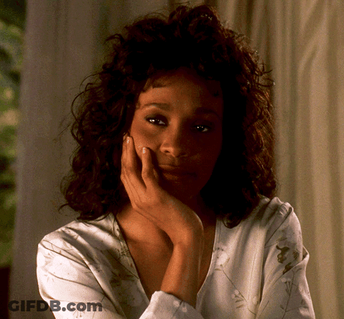 A Woman With A Hand On Her Face Looks At The Camera GIF