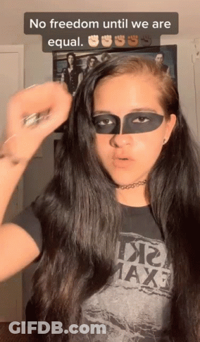 A Woman With A Mask On Her Face Is Wearing A T-Shirt That Says Maxf GIF