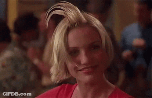 A Woman With A Mohawk Is Smiling And Looking At The Camera In A Crowded Room . GIF