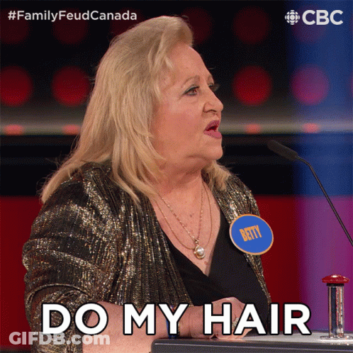 A Woman With A Name Tag That Says Betty Stands In Front Of A Microphone And Says " Do My Hair " GIF