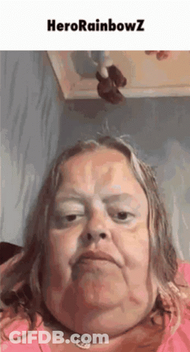 A Woman With A Necklace Around Her Neck Is Making A Funny Face With The Words Herorainbowz Above Her . GIF