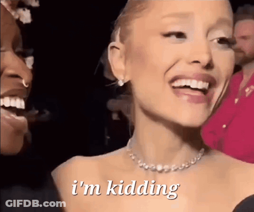 A Woman With A Necklace Is Smiling And Says I 'M Kidding . GIF