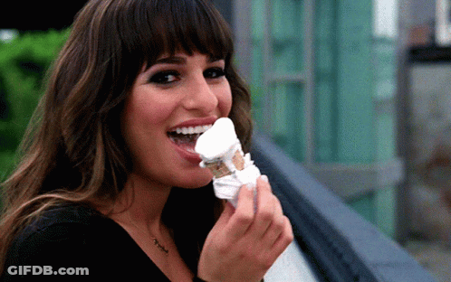 A Woman With A Necklace That Says ' I Love You ' On It Is Eating Ice Cream GIF