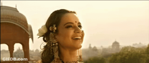 A Woman With A Nose Ring And A Flower In Her Hair Smiles GIF