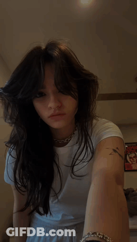 A Woman With A Nose Ring And A Tattoo On Her Arm GIF