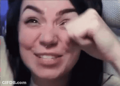 A Woman With A Nose Ring Is Crying While Holding Her Hand To Her Eye . GIF