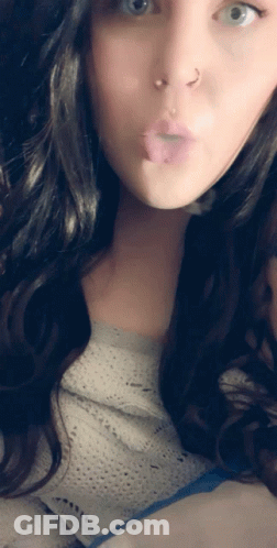 A Woman With A Nose Ring Is Making A Funny Face With Her Tongue Out GIF